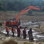 Warga berjalan melewati jalan berlumpur dan bebatuan