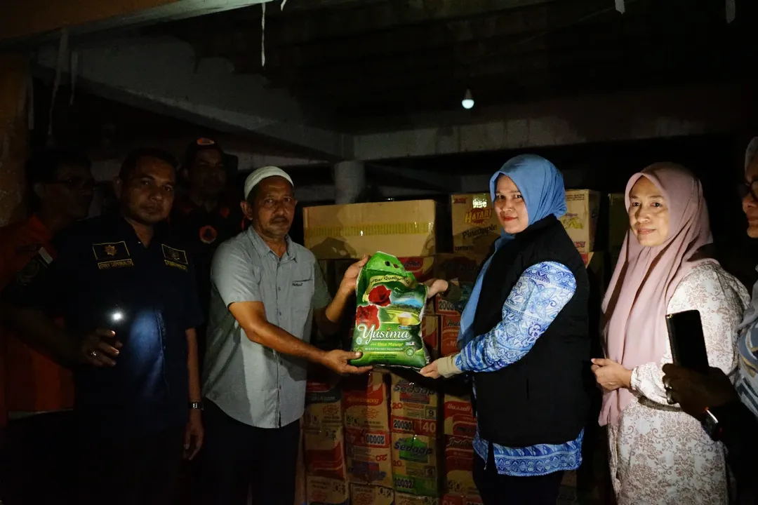 Mukarramah Fadhlullah, istri dari Wakil Gubernur (Wagub) Aceh, menyerahkan bantuan kepada warga meleaui Kepala Desa (Keuchik) Pulo, Bapak Hamdani.
