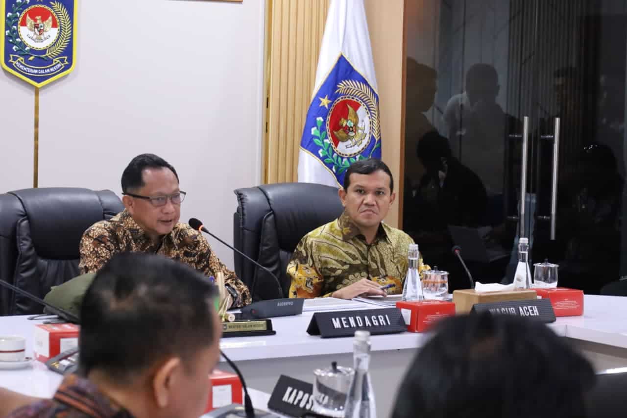 Mendagri dan pejabat pemerintah saat rapat di ruang konferensi dengan bendera Indonesia dan Aceh di.
